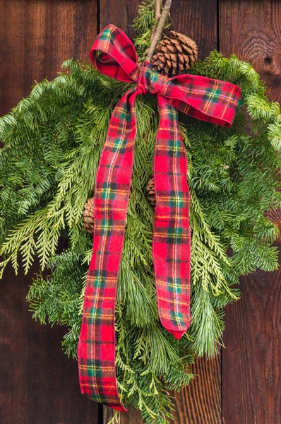 Rustic red and green flannel bow on Christmas wreath.