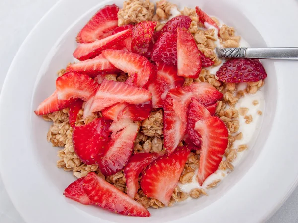 Granola, süt ve kesme çilek beyaz kase.