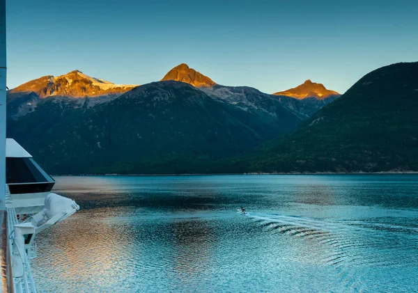Taiya Inlet, mountains and boat on calm early morning from deck of ship, Alaska. — Stock Photo, Image