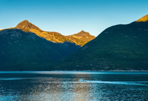 Pequeno barco e nascer do sol lon calma manhã cedo em Taiya Inlet, Skagway, Alasca . — Fotografia de Stock