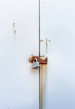 Metal kapılarda paslı hasp asılı kilitli basit metal asma kilit.