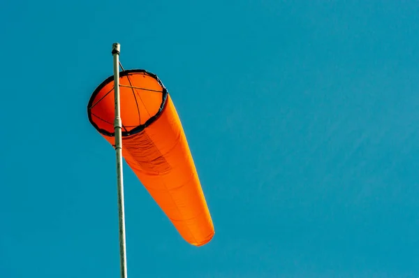 Downward angled plain orange windsock against a clear blue sky. — Stock Photo, Image