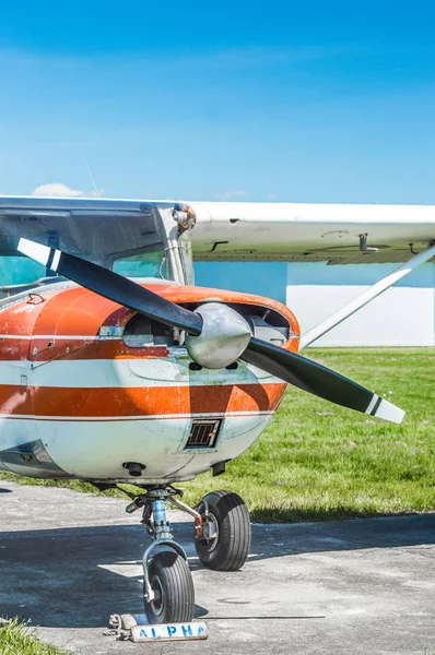 Вид спереди старого красно-белого одномоторного винтового самолета на травяном поле . — стоковое фото