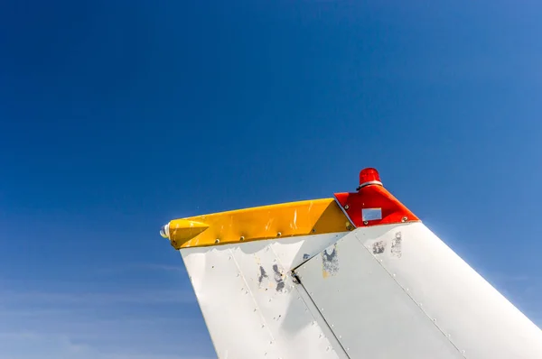 Fin cauda, leme e luzes farol, pequeno avião monomotor com pintura antiga e céu azul brilhante . — Fotografia de Stock