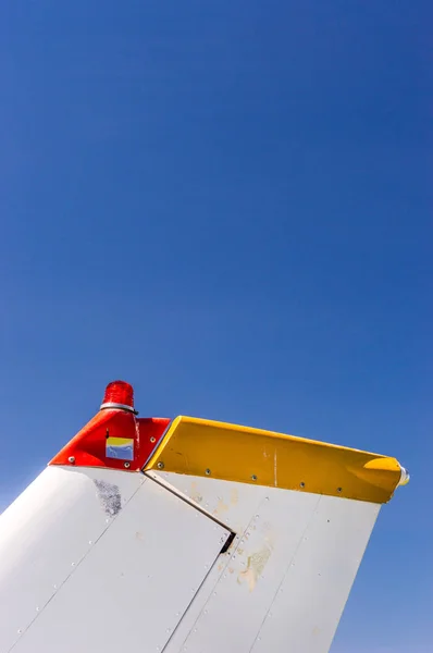 Pinna posteriore, fanali del timone e del faro, piccolo aeroplano monomotore con vecchia vernice e cielo blu brillante . — Foto Stock