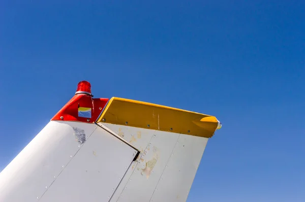 Staartvinnen, roer-en zwaailichten, kleine éénmotorige vliegtuig met oude verf en helder blauwe hemel. — Stockfoto