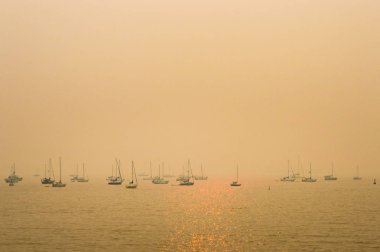 Vancouver, Bc - 22 Ağustos 2018: English Bay'de iç orman yangınlarından duman bulutu yla demirleyen tekneler.