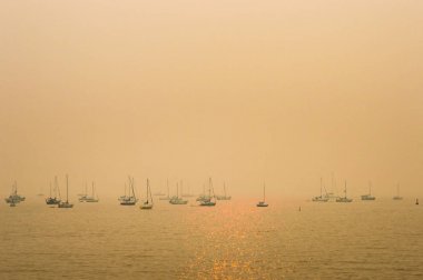 Vancouver, Bc - 22 Ağustos 2018: English Bay'de iç orman yangınlarından duman bulutu yla demirleyen tekneler.