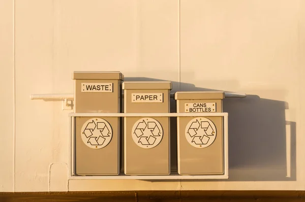 Drei aufgeräumte Abfall- und Recyclingbehälter hingen an der Wand des Kreuzfahrtschiffes. — Stockfoto