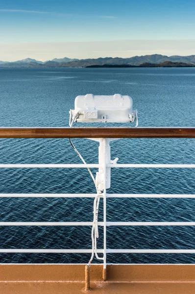 White metal exterior light fixture on railing of cruise ship, Alaska Inside Passage route. Stock Image