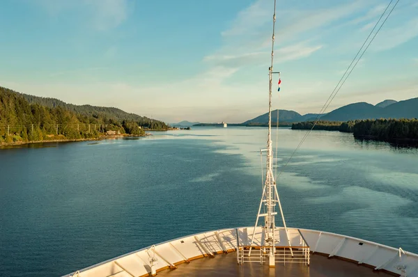 Pointed bow of cruise ship , southbound on ocean channel, Alaska Inside Passage, in warm afternoon sun. — Stock Photo, Image