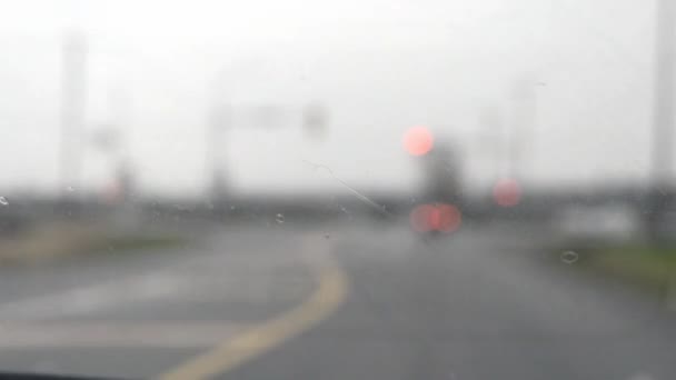 Autofahren bei Regen, unscharfer Hintergrund und Scheinwerfer, trister Tag, Handheld. — Stockvideo