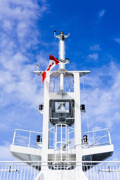 Белая башня связи корабля, вид снизу с канадским флагом на облачно-голубое небо . — стоковое фото
