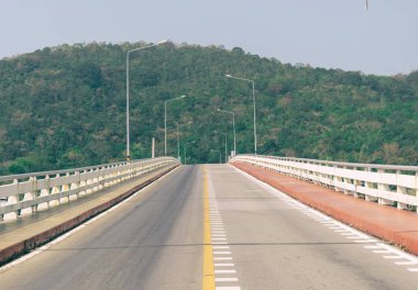 Deniz dağlık arka plan üzerinde yol köprü