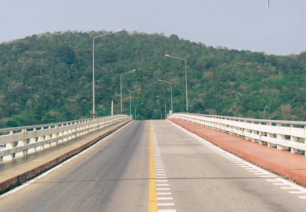 Deniz dağlık arka plan üzerinde yol köprü