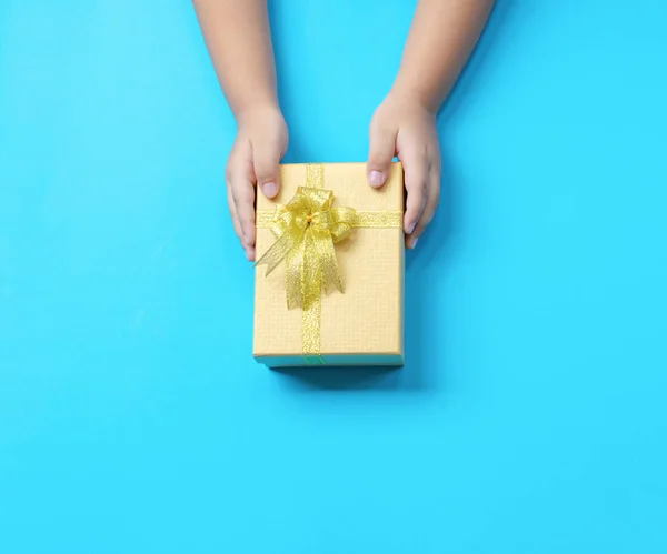 Hands on the table Gift giving New Year and Christmas or child son give a gift to the mother blue background