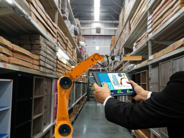 bir tablet akıllı robot sanayi kolu ürünleri depolama fabrika ve depo tutan işadamı el