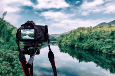 Üç ayaklı fotoğraf makinesindeki kamera manzaralı görüntüler alıyor..