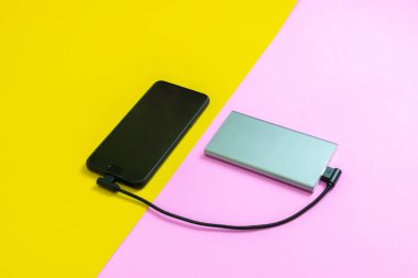 Akıllı telefon cep telefonları güç bankası pembe ve sarı arka plan tarafından pil şarj