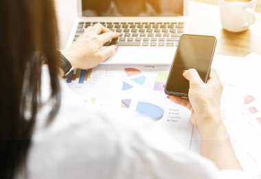 Kadınlar grafikleri analiz eder ve iş dünyasından elde edilen finansal karları listeler