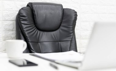 Yönetici koltuğunda kahve ve bilgisayar var.