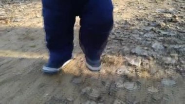 Bir yaşında bebek yürür. Küçük bir çocuk yürümek. Ayakları yere 69 git