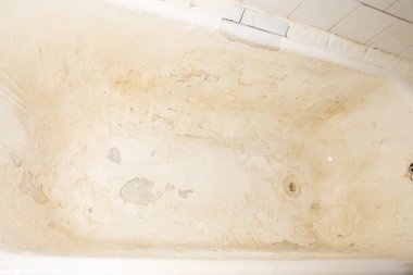 Eski kırık dökme demir küvet. Banyo kapağı hasarlı.
