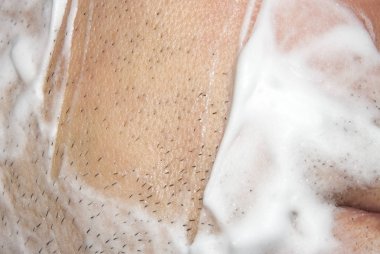 Bir adam makine tıraş. Arka plan tıraş tıraş kremi ile.