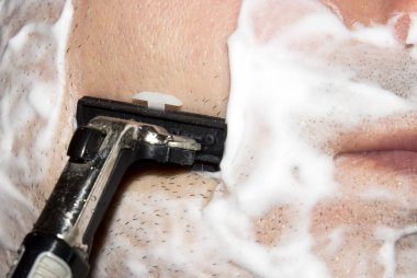 Bir adam makine tıraş. Arka plan tıraş tıraş kremi ile.