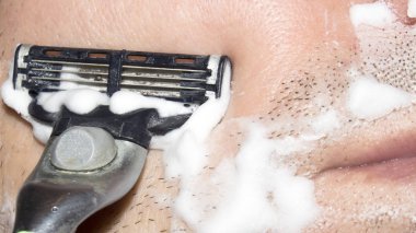 Bir adam makine tıraş. Arka plan tıraş tıraş kremi ile.