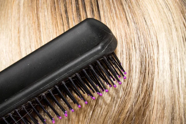 Combing female hair with a comb.Background of female hair.