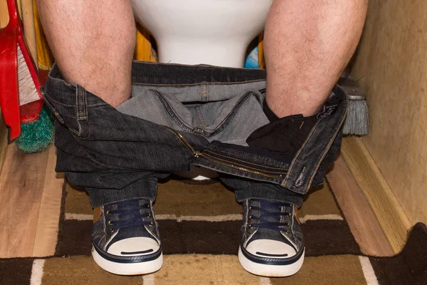 Man Zittend Het Toilet Met Zijn Broek Naar Beneden Sneakers — Stockfoto