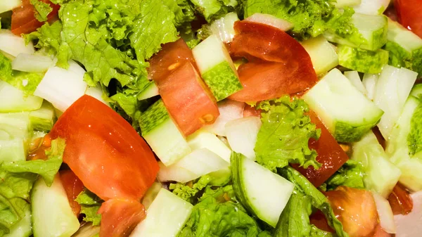 Tomato, cucumber and lettuce salad.Light salad with fresh vegetables.Background of vegetable salad.