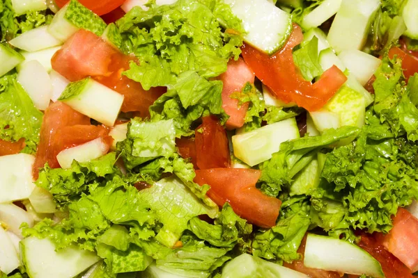 Tomato, cucumber and lettuce salad.Light salad with fresh vegetables.Background of vegetable salad.