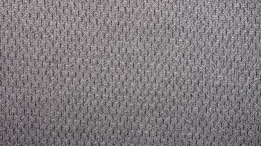 Kumaşın dokusu siyah benekli gri. Benekli tekstil içeren gri arkaplan..