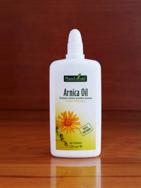 Kaloşvar, Romanya-12 Eylül 2018: Arnica masaj yağı eklem ve kas ağrısı için. Arnika montana bitkisel özü.