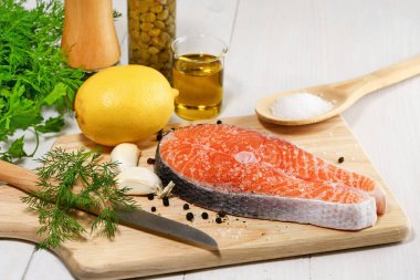 Çiğ somon fileto, madalyon kuru tedavi, tuz ve şeker ve pişirme somon ahşap tahta üzerinde piccata için malzemeler.