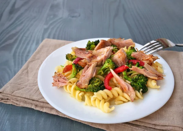 Massa Fusilli com carne de frango puxada, brócolis e legumes na placa branca — Fotografia de Stock