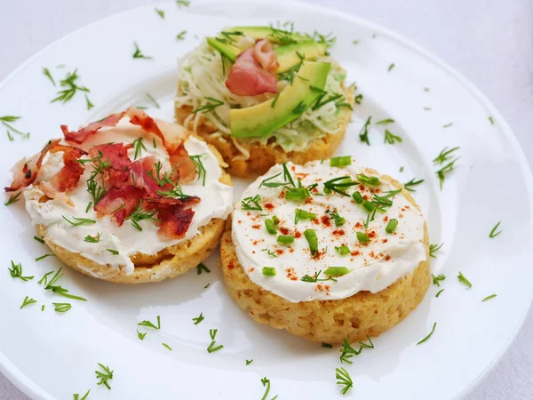 Canapés com queijo creme, bacon, abacate espalhados por fatias de pão de caneca de amêndoa — Fotografia de Stock