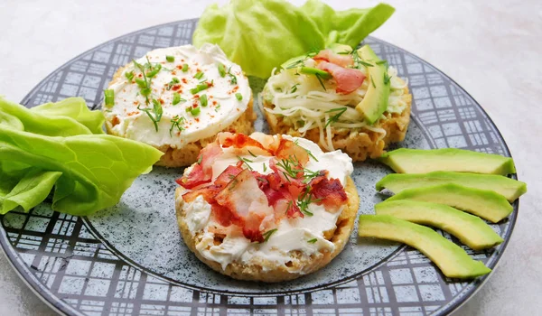 Canapés com queijo creme, bacon, abacate espalhados por fatias de pão de caneca de amêndoa — Fotografia de Stock