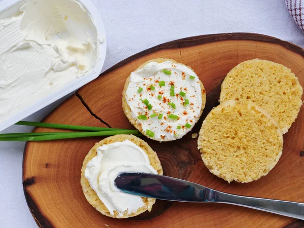 Spreading cream cheese on a slice of keto almond flour bread — Stock Photo, Image