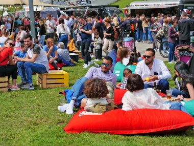 İnsanlar rahatlar ve şişme kauçuk şiltelerde yemek yerler.