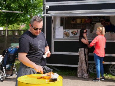Orta yaşlı adam davul masasında sokak yemeği yiyor