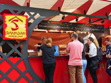 İnsanlar Çin yemeği almak için sırada duruyorlar.