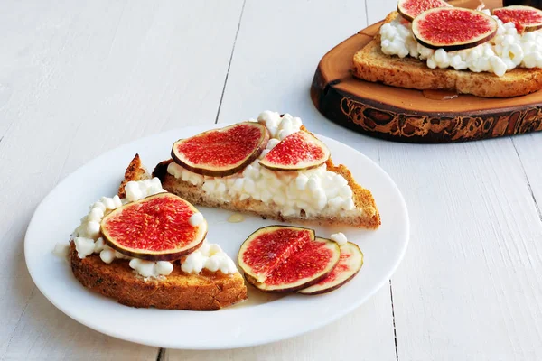 Toast with cottage cheese, figs and honey on white plate — Stock Photo, Image