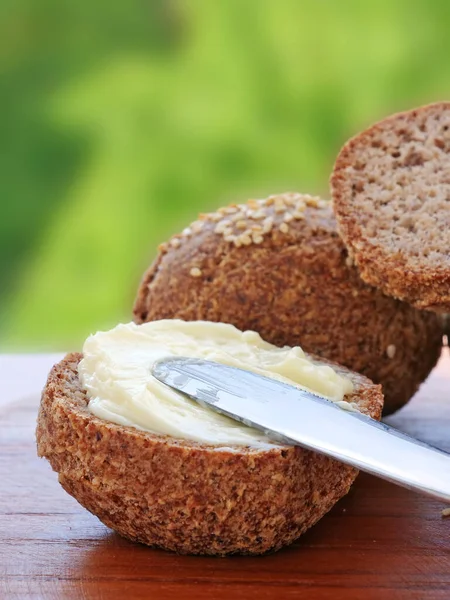 Butter Auf Krustigem Ketogenem Mandelmehlbrot Verteilen Senkrecht lizenzfreie Stockbilder