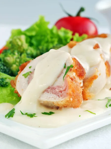 Cordone Pollo Bleu Affettato Con Crema Parmigiano Verdure Verticale Foto Stock