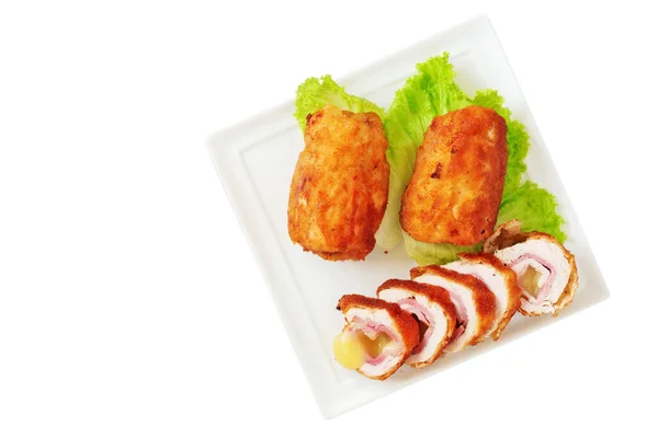 Chicken cordon bleu schnitzel, meat wrapped around ham and cheese, breaded and fried on white porcelain platter isolated