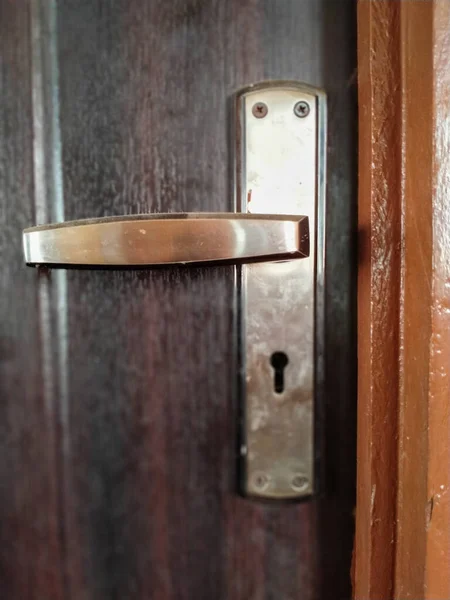 Golden Door handle in a wooden door