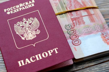 5000 ruble, biyometrik pasaport ve pasaport ahşap arka plan üzerinde Rusya Federasyonu Rus paradır. Yurtdışında seyahat kavramı.